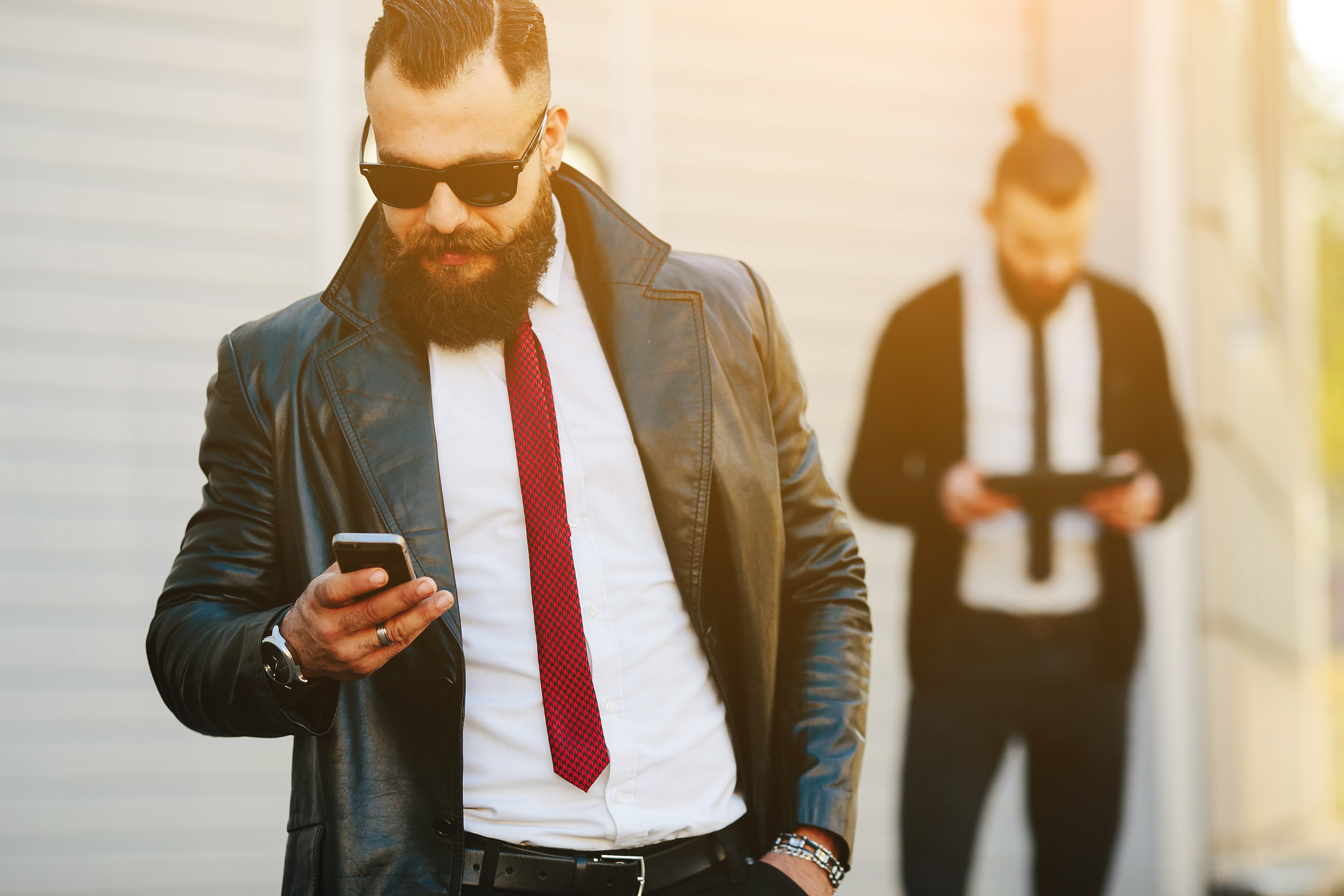 Two bearded businessman working on the street